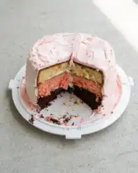 A tall sliced Neapolitan Anniversary Cake showing distinct chocolate vanilla and strawberry layers