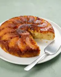 A golden No Bake Caramel Peach Upside Down Cake resting in a non-stick skillet after cooking.