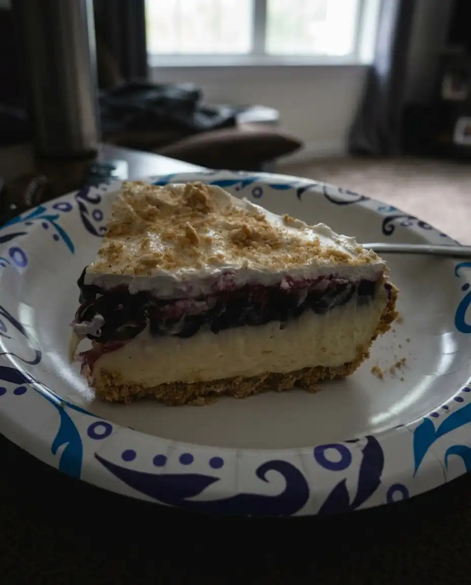 No Bake Lemon Blueberry Dessert 10 A layered no bake lemon blueberry dessert in a glass dish showing distinct crust lemon and berry layers.