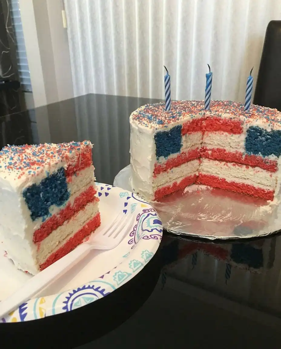 A single slice of flag cake on a white plate with stars in the background