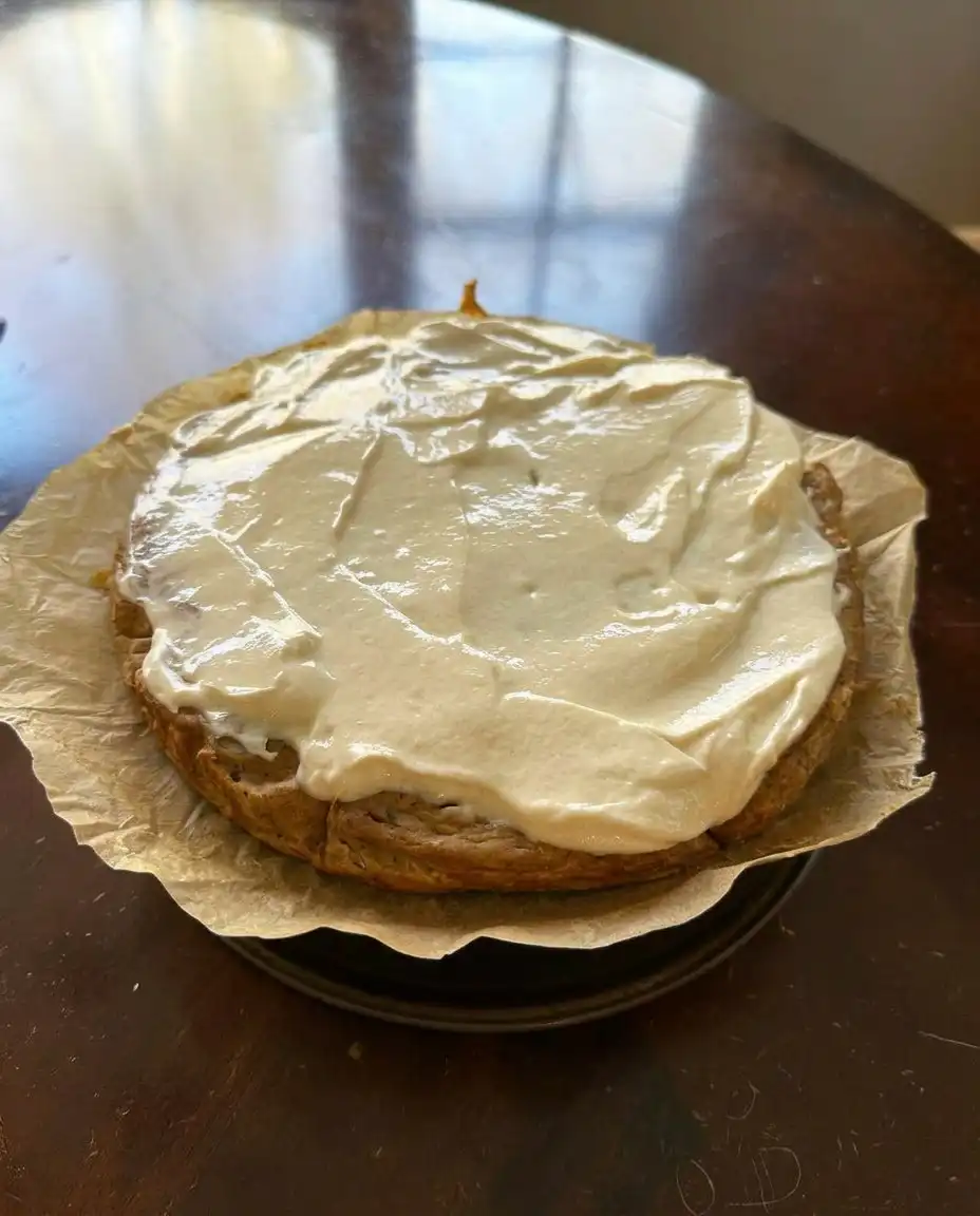 A square of zucchini banana cake with maple frosting on a white plate