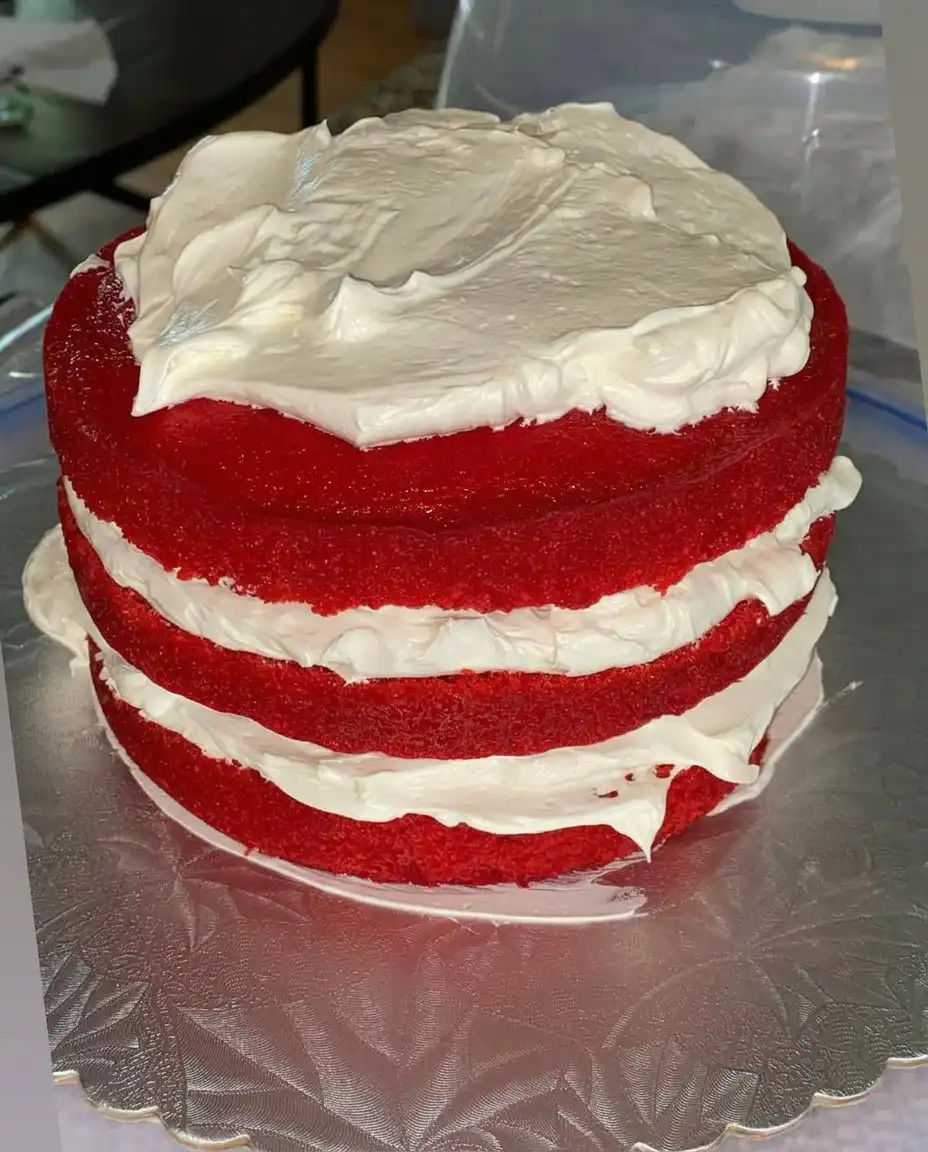 Using a fork to poke holes in a warm white cake