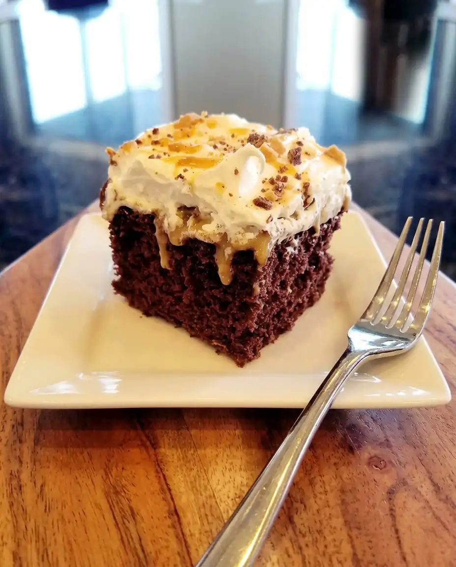 A hand using a fork to poke uniform holes into a warm chocolate cake.