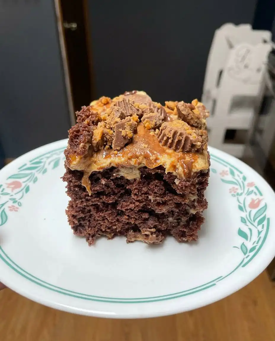 Wooden spoon poking holes into a freshly baked chocolate cake for a poke cake recipe
