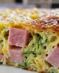 Slices of savory zucchini pie with melted cheese and fresh herbs