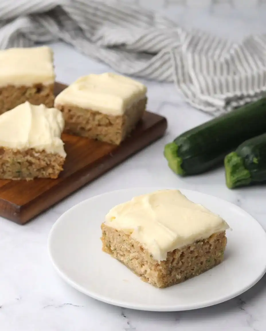A serving of Zucchini Bars next to a cup of hot coffee.