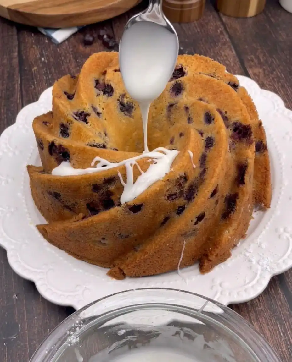 Cherry Amaretto Bundt Cake 13 A pastry chef sifting cake flour into a mixing bowl to aerate the batter.