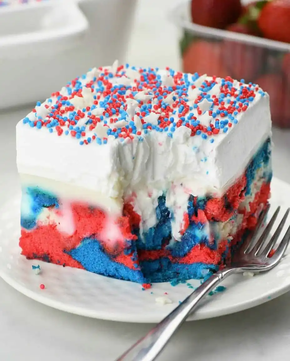 A slice of red, white, and blue poke cake on a plate