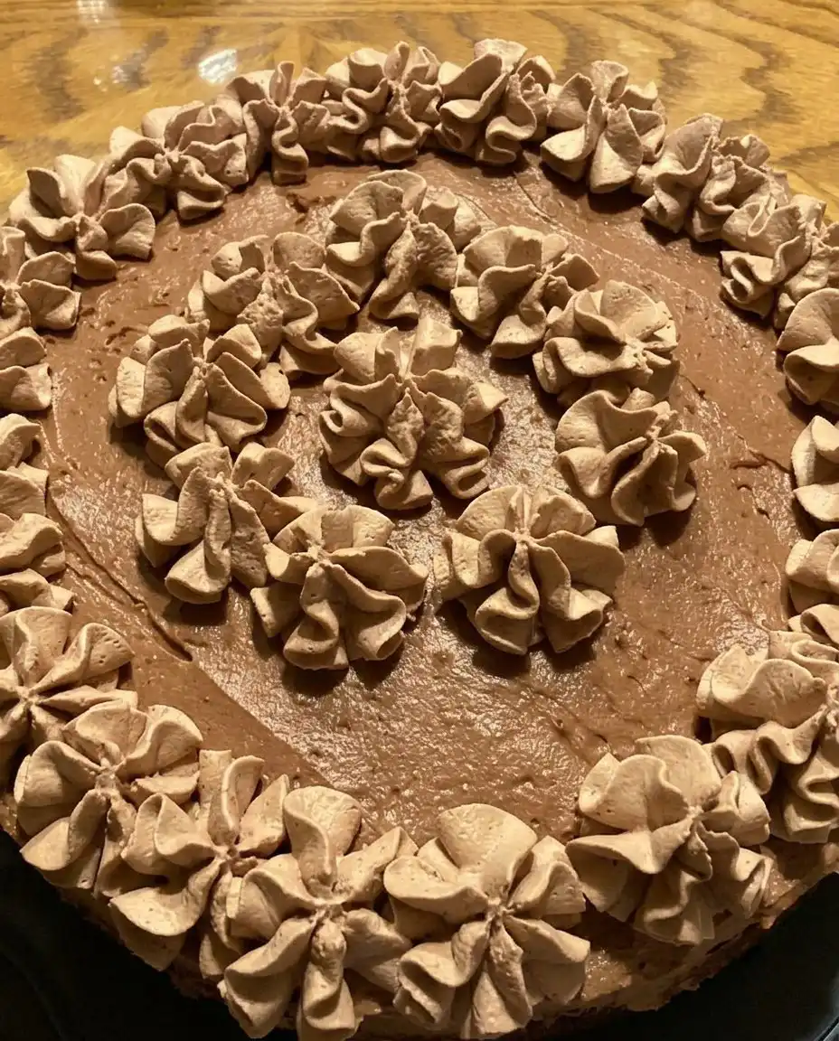 A professional presentation of a chocolate mousse cake slice on a white plate with clean edges.