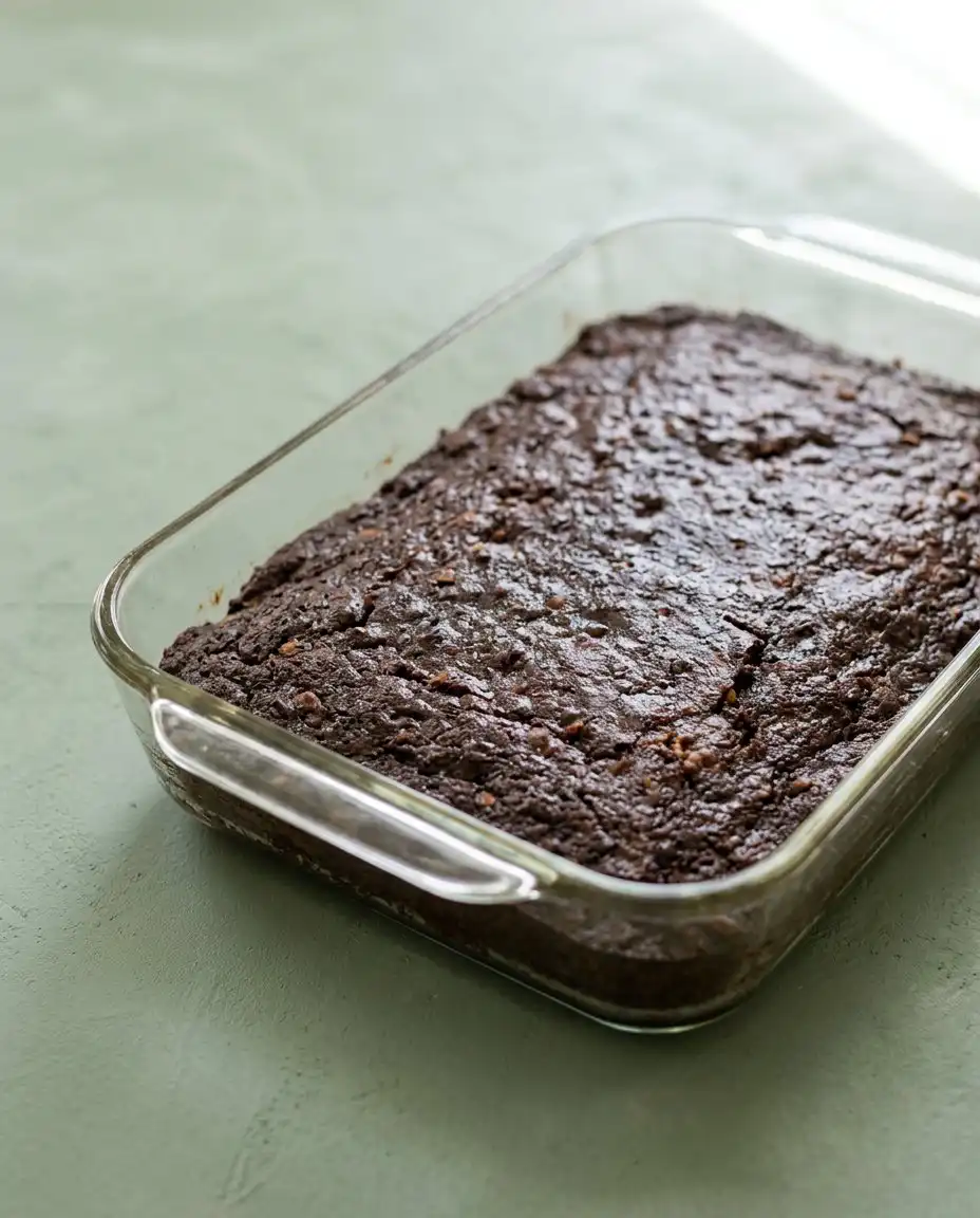 Old-Fashioned Chocolate Zucchini Cake 16 A square slice of Old-Fashioned Chocolate Zucchini Cake on a white plate.