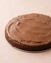 A moist Sugar-Free Chocolate Zucchini Cake loaf cooling on a wire rack with melted chips.