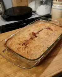 A golden brown super easy peach cobbler in a baking dish