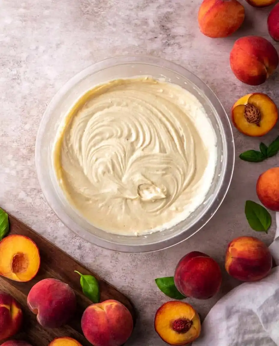 Vanilla bean whipped cream being whisked to stiff peaks in a glass bowl.
