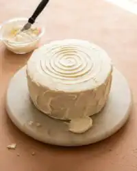 A beautifully sliced Red Velvet Layer Cake resting on a rustic ceramic plate