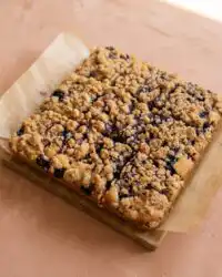 A golden classic blueberry coffee crumb cake freshly baked in a metal pan