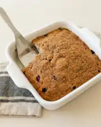 A freshly baked Classic Blueberry Coffee Cake in a square baking pan showing golden streusel topping.