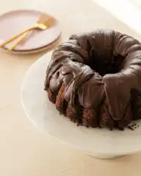 A beautiful whole Double Chocolate Zucchini Cake baked in a bundt pan on a wire cooling rack.