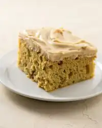 A freshly baked zucchini cake with cinnamon and nutmeg cooling on a wire rack.