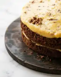 Two fresh baked German Chocolate Cake layers cooling on a wire rack.