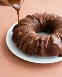 Freshly baked healthy chocolate zucchini cake resting on a professional steel cooling rack.