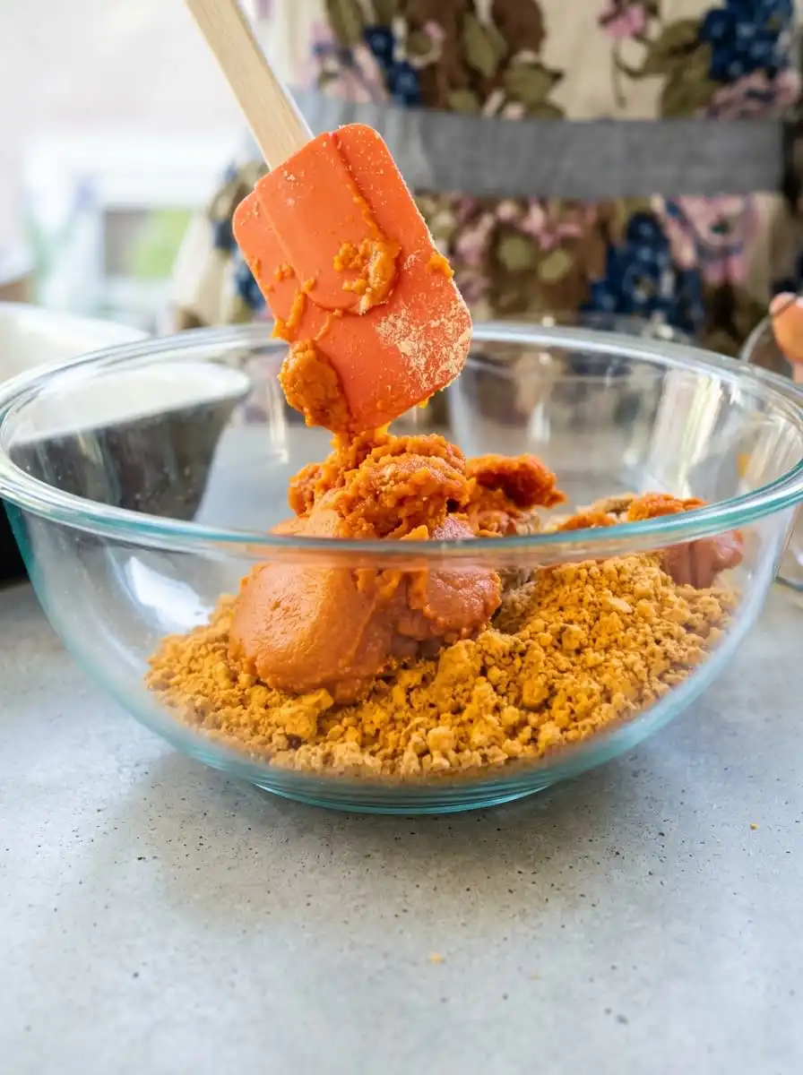 A box of spice cake mix beside a can of pure pumpkin puree on a sunlit wooden table to make Two Ingredient Pumpkin Spice Cake