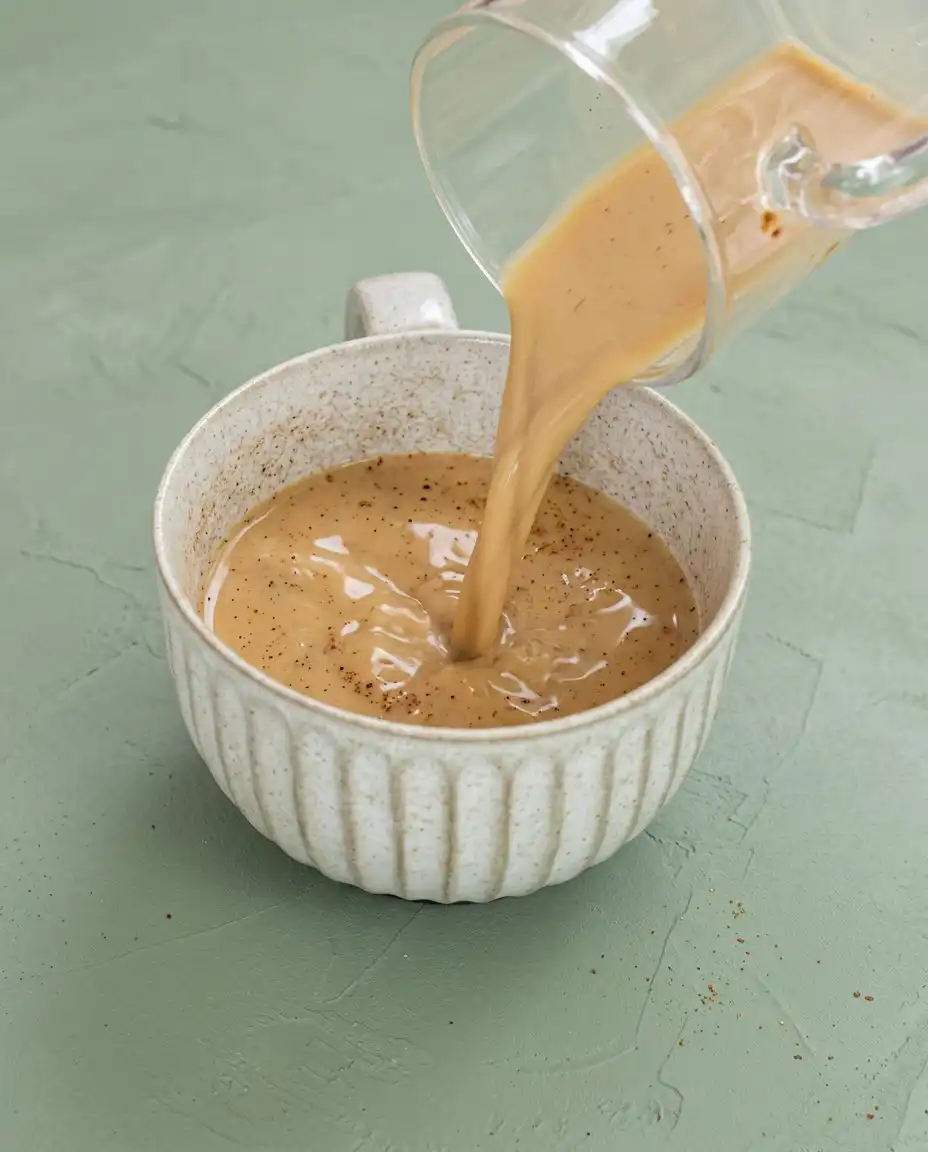 Checking the internal crumb structure of a chocolate mug cake with a clean wooden skewer to ensure it is set.