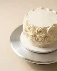 A perfect slice of moist White Velvet Cake layered with silky Ermine frosting on a plate.