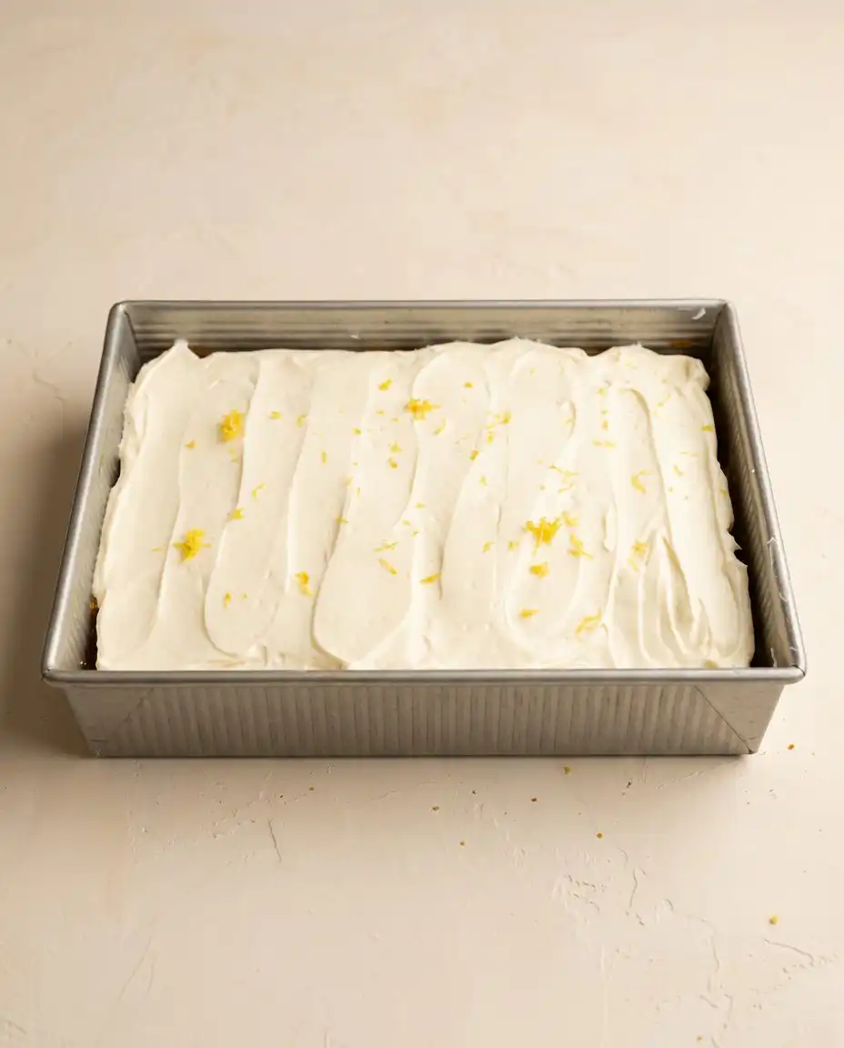 Zucchini Cake with Lemon Cream Cheese Frosting 12 A slice of zucchini cake with lemon cream cheese frosting on a rustic ceramic plate.