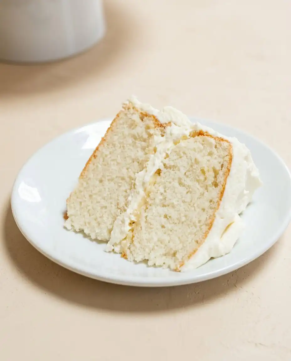 A delicate slice of Two-Layer Buttermilk Cake served on a vintage plate.