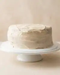 A close-up slice of Pumpkin Spice Layer Cake with Cinnamon Cream Cheese Frosting on a rustic plate