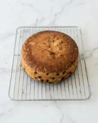 A golden slices of baked Blueberry Lemon Olive Oil Cake resting on a rustic wooden table with fresh berries.