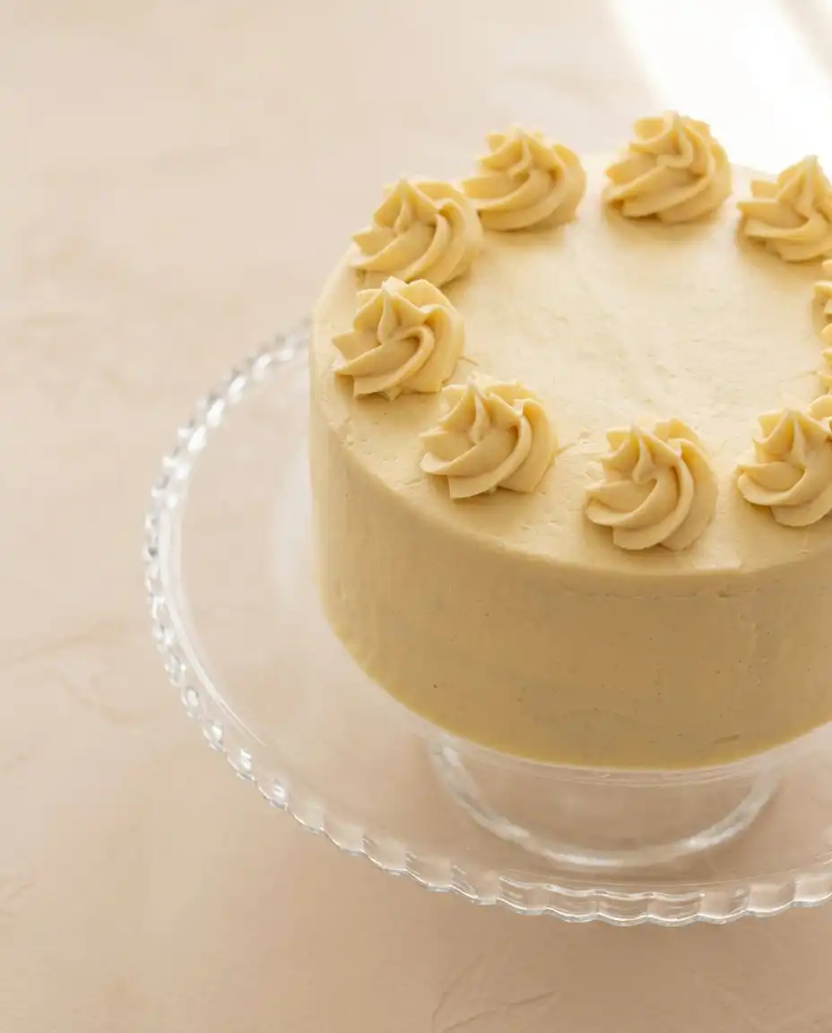 A single slice of Apple Spice Birthday Cake served on a plate with vanilla ice cream.