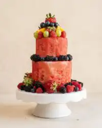 A stunning tiered Classic Watermelon Fruit Cake decorated with fresh colorful summer berries.