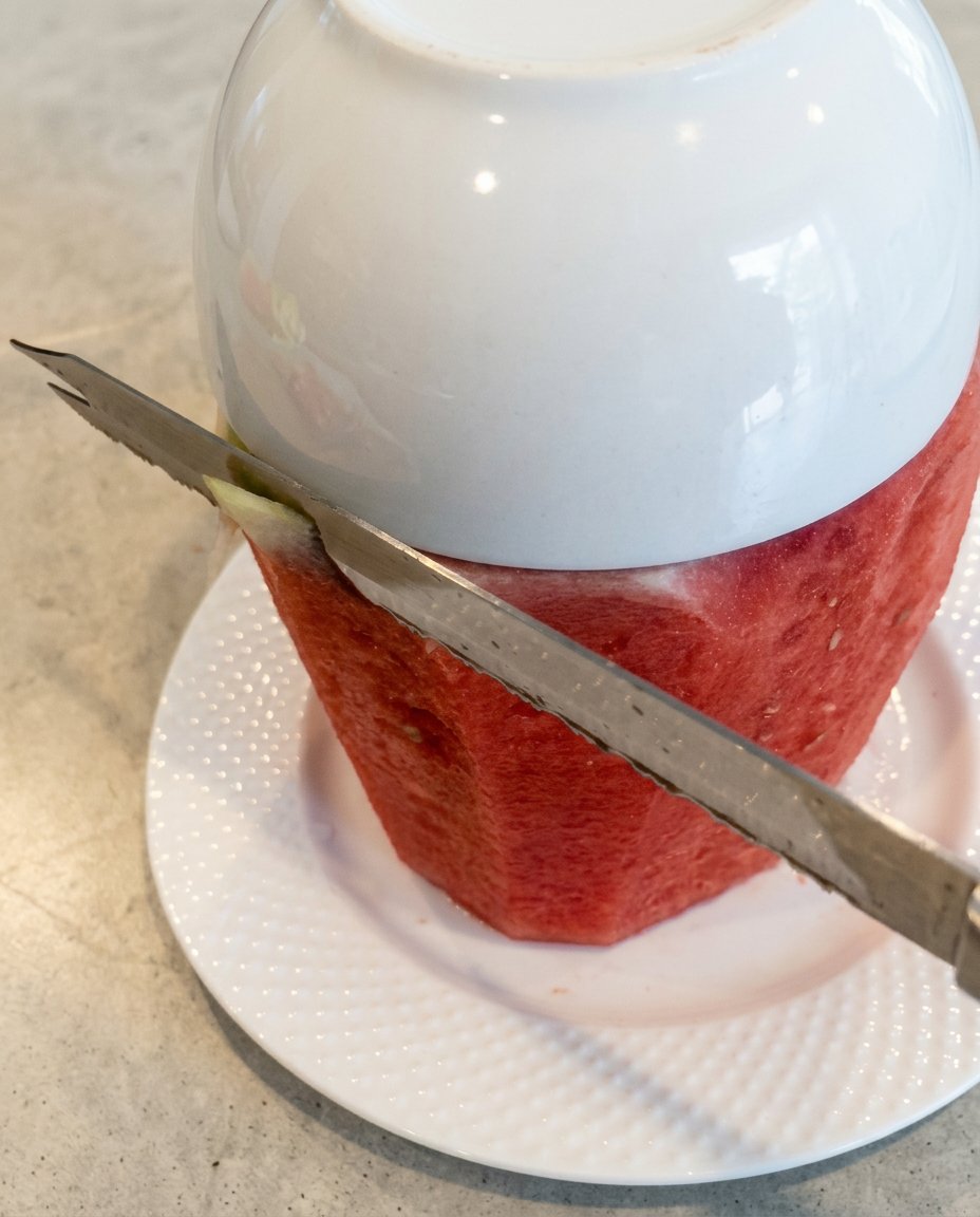 Fresh watermelon blocks alongside cans of organic coconut milk and berries.