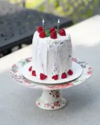 A gorgeous Watermelon Cake with Whipped Coconut Frosting decorated with fresh berries.